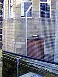 Welded mesh supported on galvanised steel fence posts - fence post fitted to top of an existing wall
