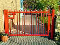 Red powder coated bow top vertical bar access gate - designed with minimal protruding steel work for a school play area
