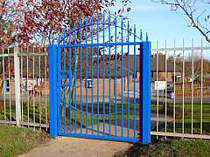 Blue powder coated vertical bar access gate incorporating a bowed top