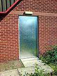 Galvanised sheet steel cladding to a existing building access door - steel sheeting secured with 1-way clutch screws
