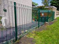 Green powder coated mesh panel fencing - mesh panels secured with mesh clamp bars to provide additional security
