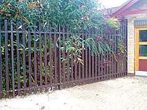 Brown powder coated palisade fencing incorporating a raked end panel