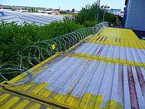 710mm dia. concertina razor wire fixed to the top of some storage containers