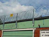 Flat wrapped razor wire supported on galvanised angle steel brackets