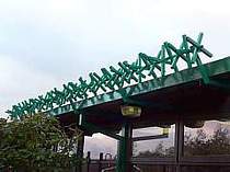 350mm powder coated rotating spikes fixed to building roof edge - powder coating colour matched to the building paint colour