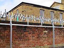 350mm dia. galvanised rotating spikes fixed along the top edge of an existing wall on independent support posts - the company who commissioned the works was not allowed to fix anything directly to the boundary wall