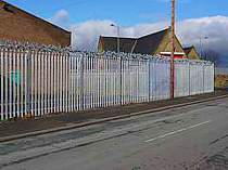 350mm galvanised rotating spikes fixed to the top of a palisade fence - support brackets cranked inwards towards the property to make sure the rotating spikes do not extend into the public pavement