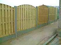 Wood panel fence using concrete slotted posts and gravel boards